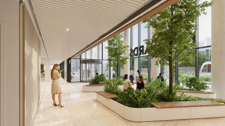 Modern lobby of New Yards Haymarket, Edinburgh, featuring indoor plants with seating and a revolving glass door.